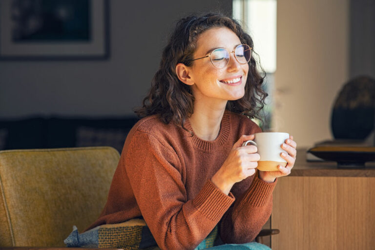 girl holding a cup of coffee and smiling