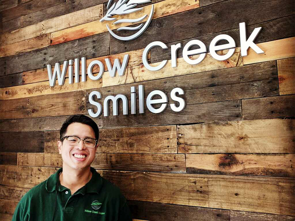 dr nguyen in front of office sign